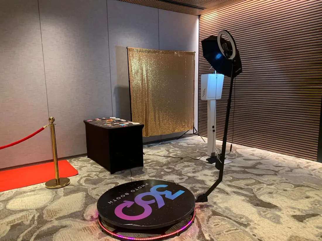 360 booth with red carpet, stanchion and gold sequin backdrop