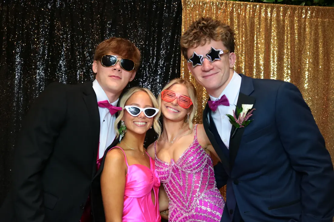 Friends in party sunglasses at a sequin backdrop